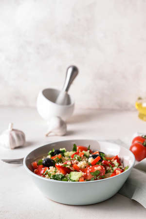 Bowl with couscous and vegetables on light backgroundの写真素材