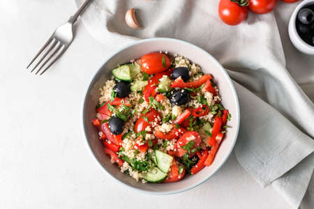 Bowl with couscous and vegetables on light backgroundの写真素材