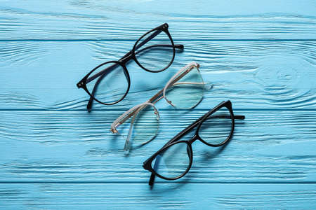 Different stylish eyeglasses on color wooden backgroundの写真素材