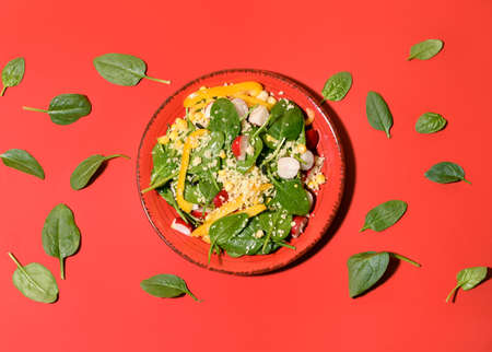 Composition with tasty couscous and spinach leaves on color background