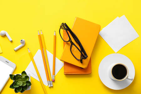 Different office tools, cup of coffee, glasses and devices on color table