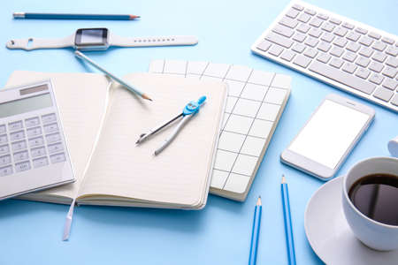 Different office tools, cup of coffee and devices on color tableの写真素材