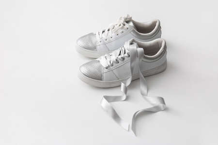 Stylish shoes with silver ribbon on white backgroundの写真素材