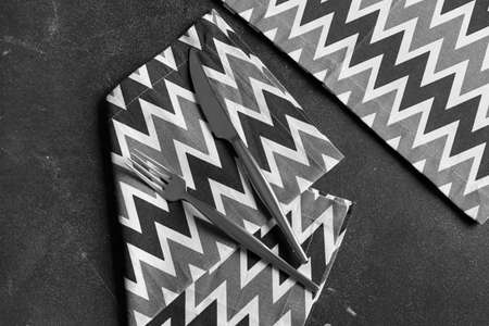 Cutlery and stylish napkins on dark background