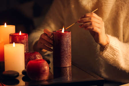 Woman lightning candles at table, closeupの写真素材