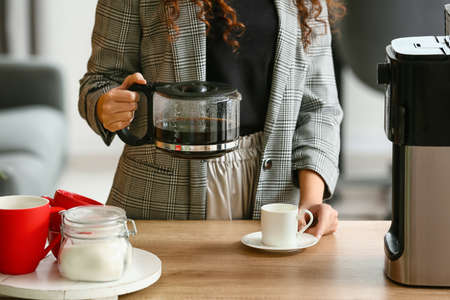 Young woman making coffee in the kitchen