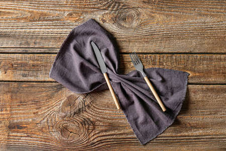 Cutlery and stylish napkin on wooden backgroundの写真素材