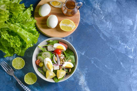 Plate with healthy salad with eggs on color backgroundの写真素材