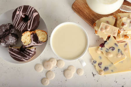 Cup with hot white chocolate on light background