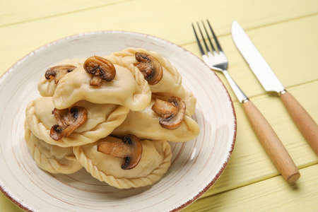 Plate with tasty dumplings on color wooden backgroundの写真素材