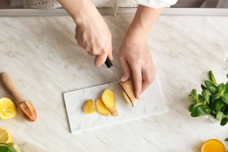 Woman preparing ginger lemonade in the kitchen