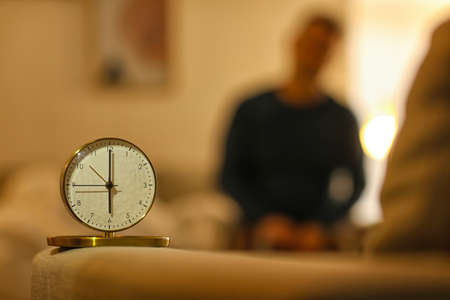 Alarm clock in room of mature man at nightの写真素材