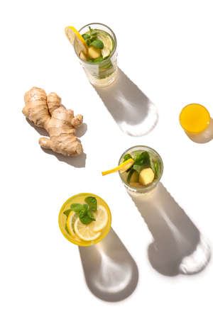 Glasses of cold ginger lemonade on white background