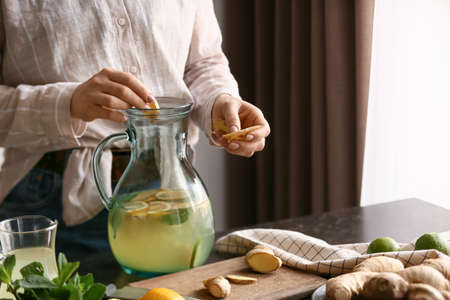 Woman preparing ginger lemonade in the kitchenの写真素材