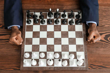 African-American man playing chess at table, top view