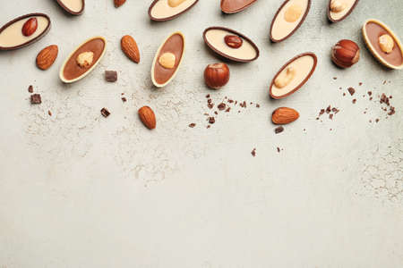 Tasty chocolate candies with nuts on light backgroundの写真素材