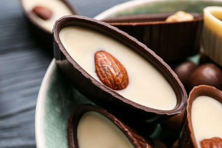Bowl with tasty chocolate candies on dark wooden background, closeupの写真素材