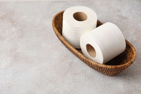 Basket with rolls of toilet paper on grunge backgroundの写真素材