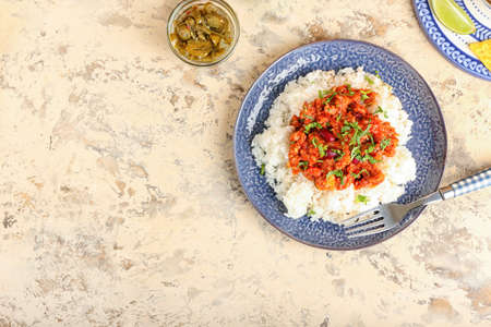 Plate with tasty chili con carne, rice and pickled jalapeno on color backgroundの写真素材