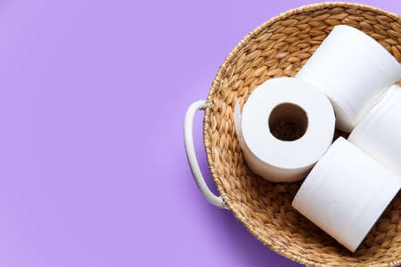 Basket with rolls of toilet paper on color backgroundの写真素材
