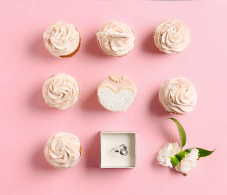 Composition with cupcakes and wedding rings on color backgroundの写真素材