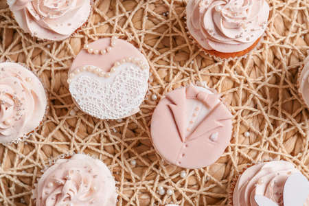 Tasty wedding cupcakes on wicker matの写真素材
