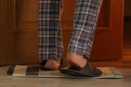 Man wearing soft slippers at home, closeup