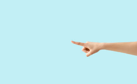 woman pointing at something on color backgroundの写真素材