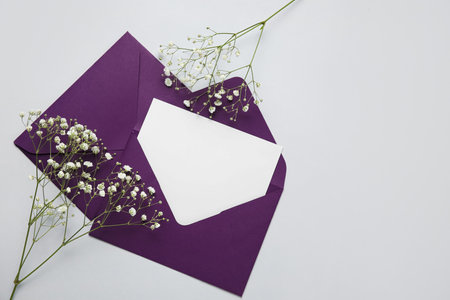 Envelopes with blank card and flowers on light backgroundの写真素材