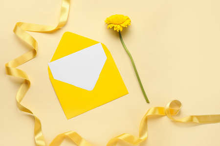 Envelope with blank card, ribbon and flower on color backgroundの写真素材