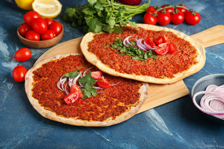 Board with delicious Turkish pizza on color backgroundの写真素材