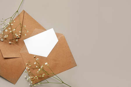 Envelopes with blank card and flowers on gray backgroundの写真素材