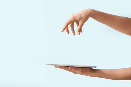 Woman with tablet computer on color backgroundの写真素材