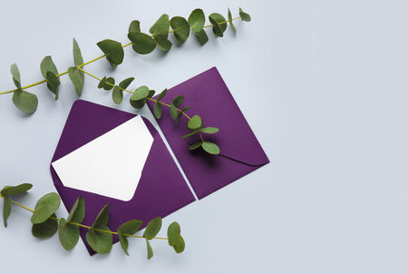 Envelopes with blank card and eucalyptus on light backgroundの写真素材