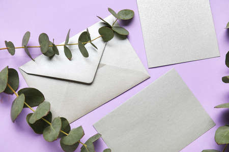 Envelopes with blank card and eucalyptus on color backgroundの写真素材