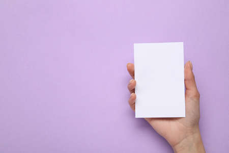 Female hand with blank card on color backgroundの写真素材