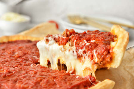 Piece of tasty Chicago-style pizza on light background, closeupの写真素材