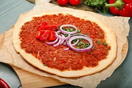 Board with delicious Turkish pizza on color wooden backgroundの写真素材