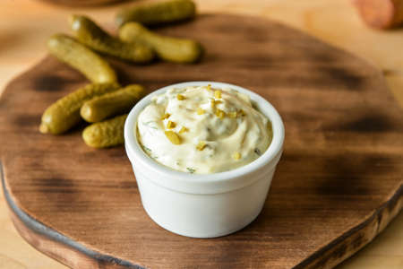 Bowl with tasty tartare sauce and pickled cucumbers on color background, closeupの写真素材
