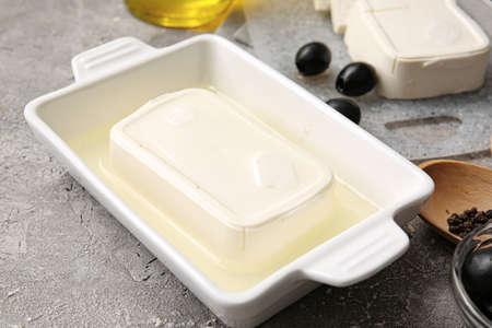 Baking dish with feta cheese on gray backgroundの写真素材