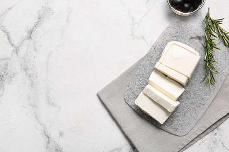 Board with feta cheese, olives and rosemary on light backgroundの写真素材