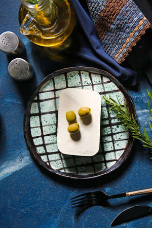 Plate with delicious feta cheese and olives on color backgroundの写真素材