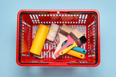 Shopping basket with painter's supplies on color backgroundの写真素材