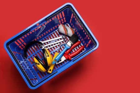 Shopping basket with builder's supplies on color backgroundの写真素材