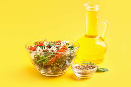 Bowl with healthy vegetable salad with flax seeds on color backgroundの写真素材