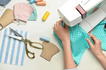 Woman sewing clothes on white background