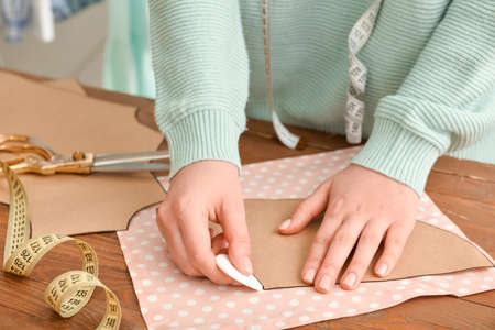 Young woman working with sewing pattern in studio