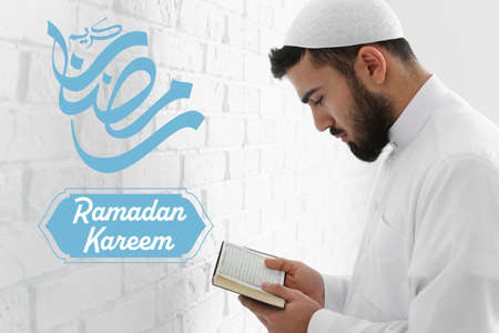 Praying Muslim man reading Quran at home. ramadan celebrationの写真素材