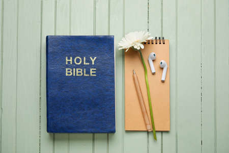 Holy Bible, earphones and flowers on wooden backgroundの写真素材