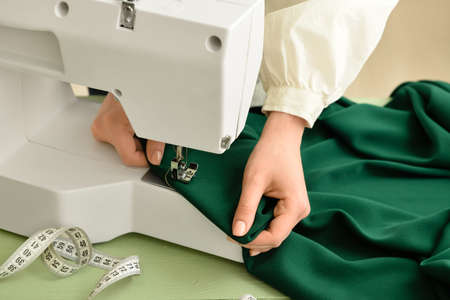 Young woman sewing clothes in studio